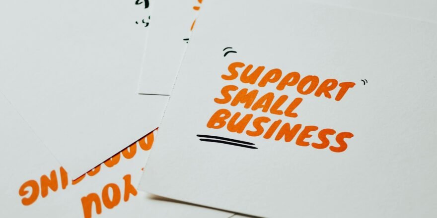 Close-up of motivational cards promoting support for small business on white background.
